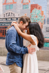The couple looking at each other, foreheads pressed together and eyes open in a silly way.