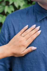 A minimalist detail showing the woman’s ring on her partner’s shoulder.